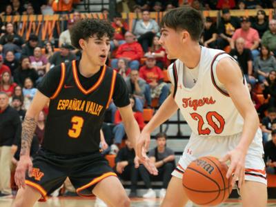 Taos' Evan Salazar guarded by Española's Jerek Duda